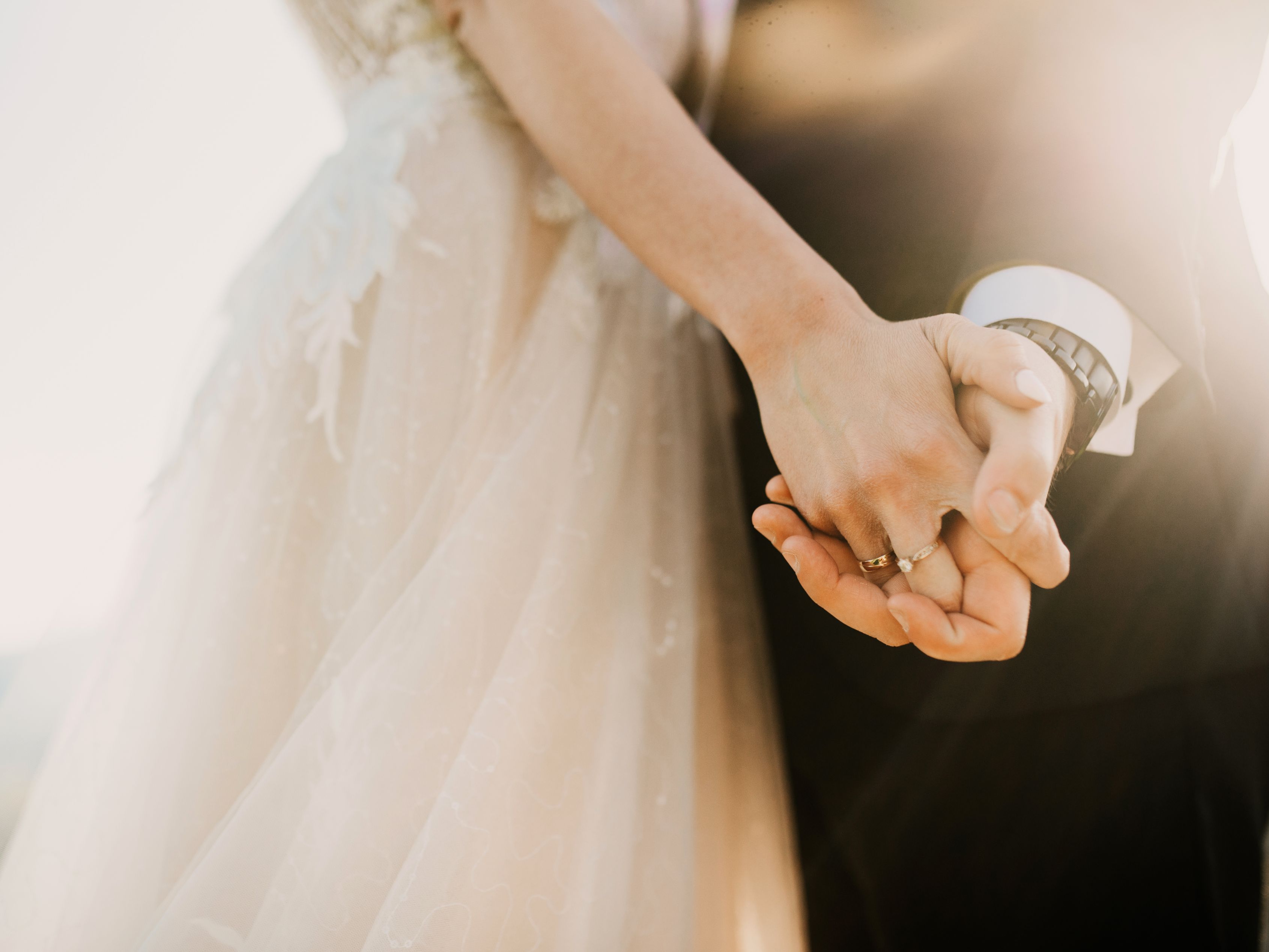 Bride and groom holding hands.