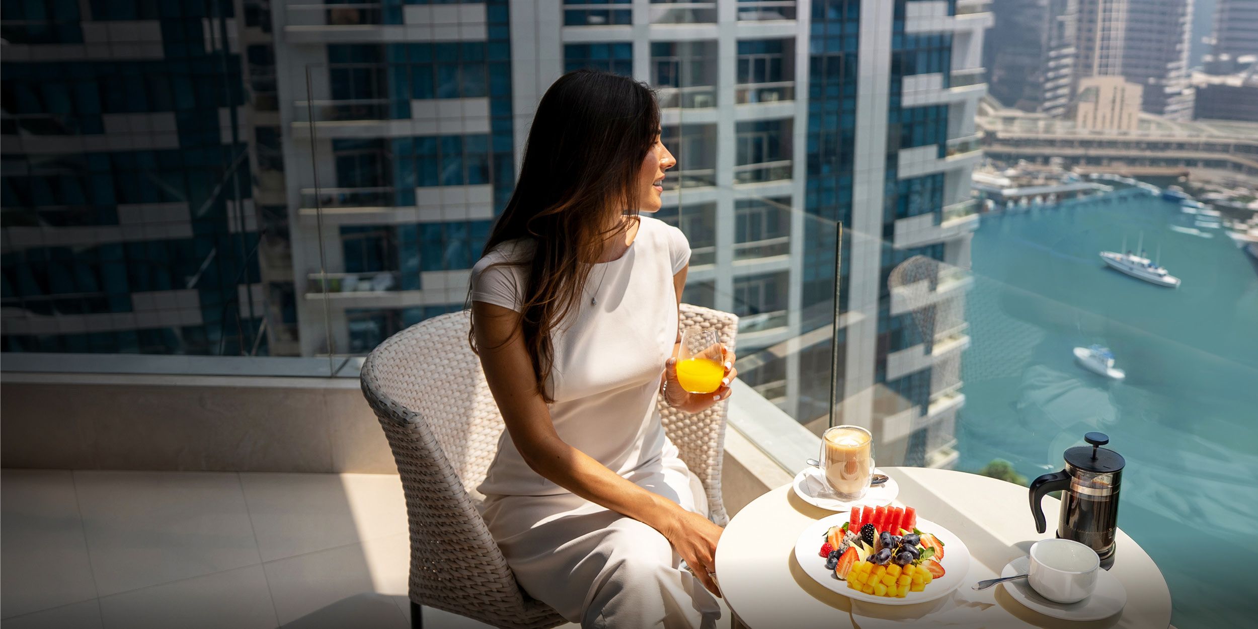 A lady enjoying breakfast in a hotel room balcony