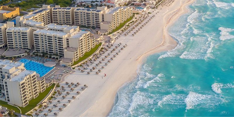 Aerial view of beachfront hotel beside turquoise ocean