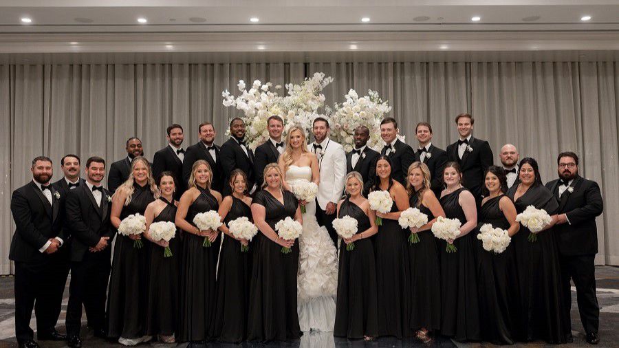 Full wedding party posing for camera