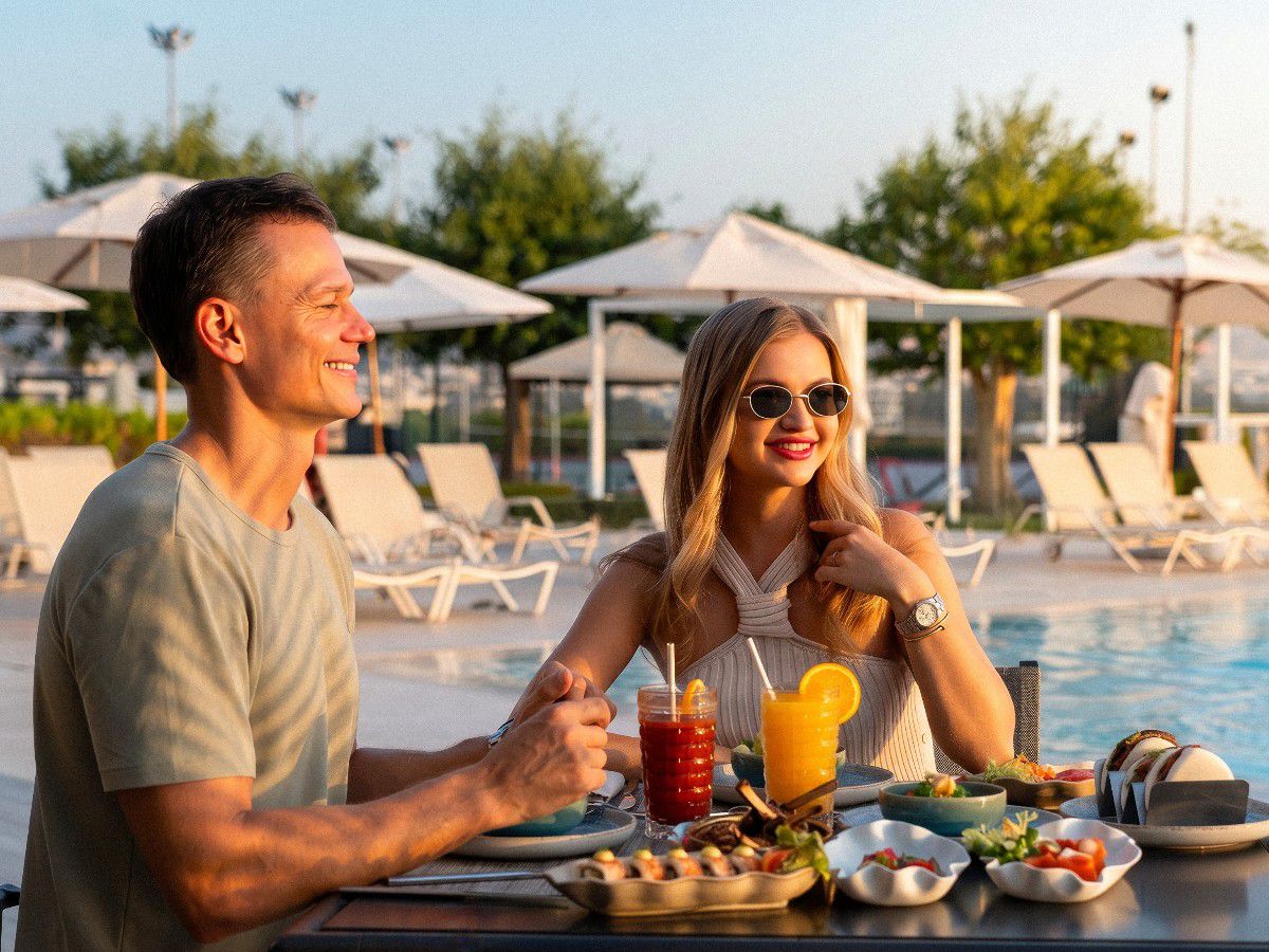 Couple enjoying brunch by outdoor poolside seating