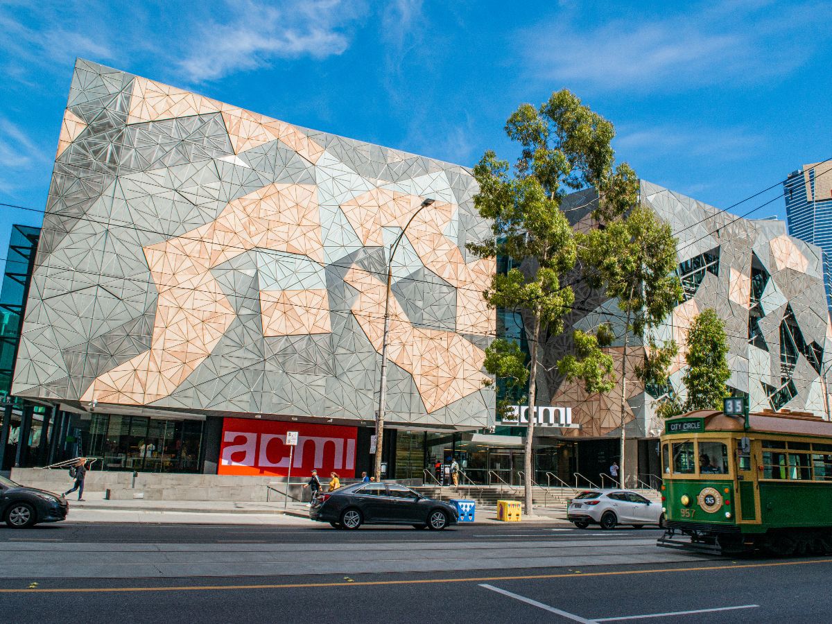 ACMI building with tram and city street.