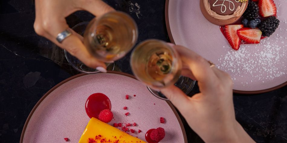 Sparkling wine toast beside chocolate dessert and berries