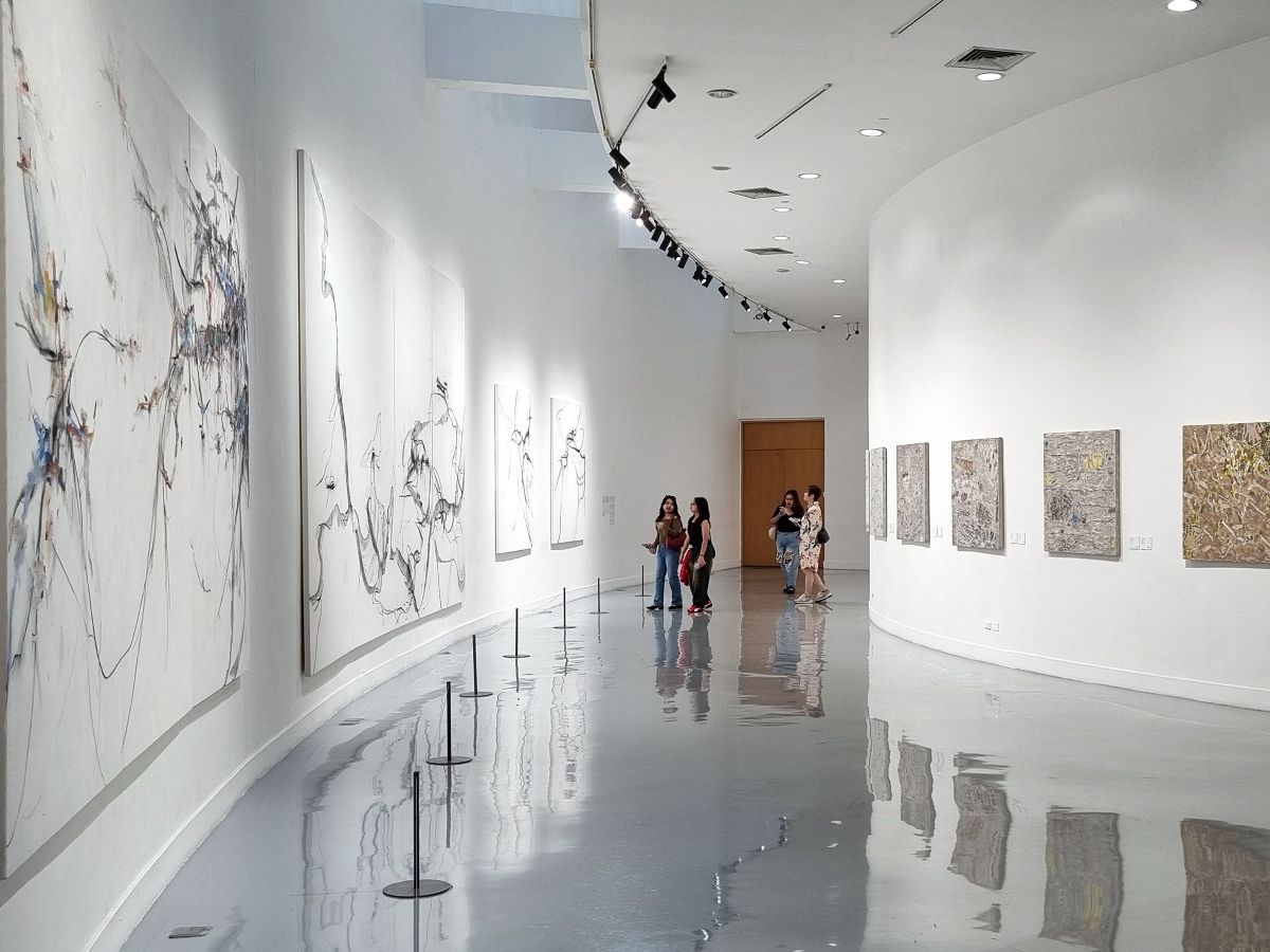 Contemporary art gallery featuring large-scale artworks in a bright exhibition space.