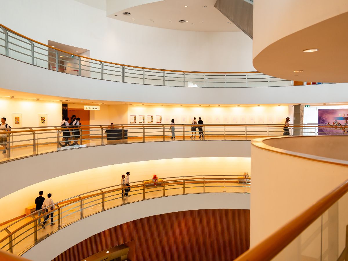 Modern multi-level gallery interior with curved walkways and exhibition spaces.