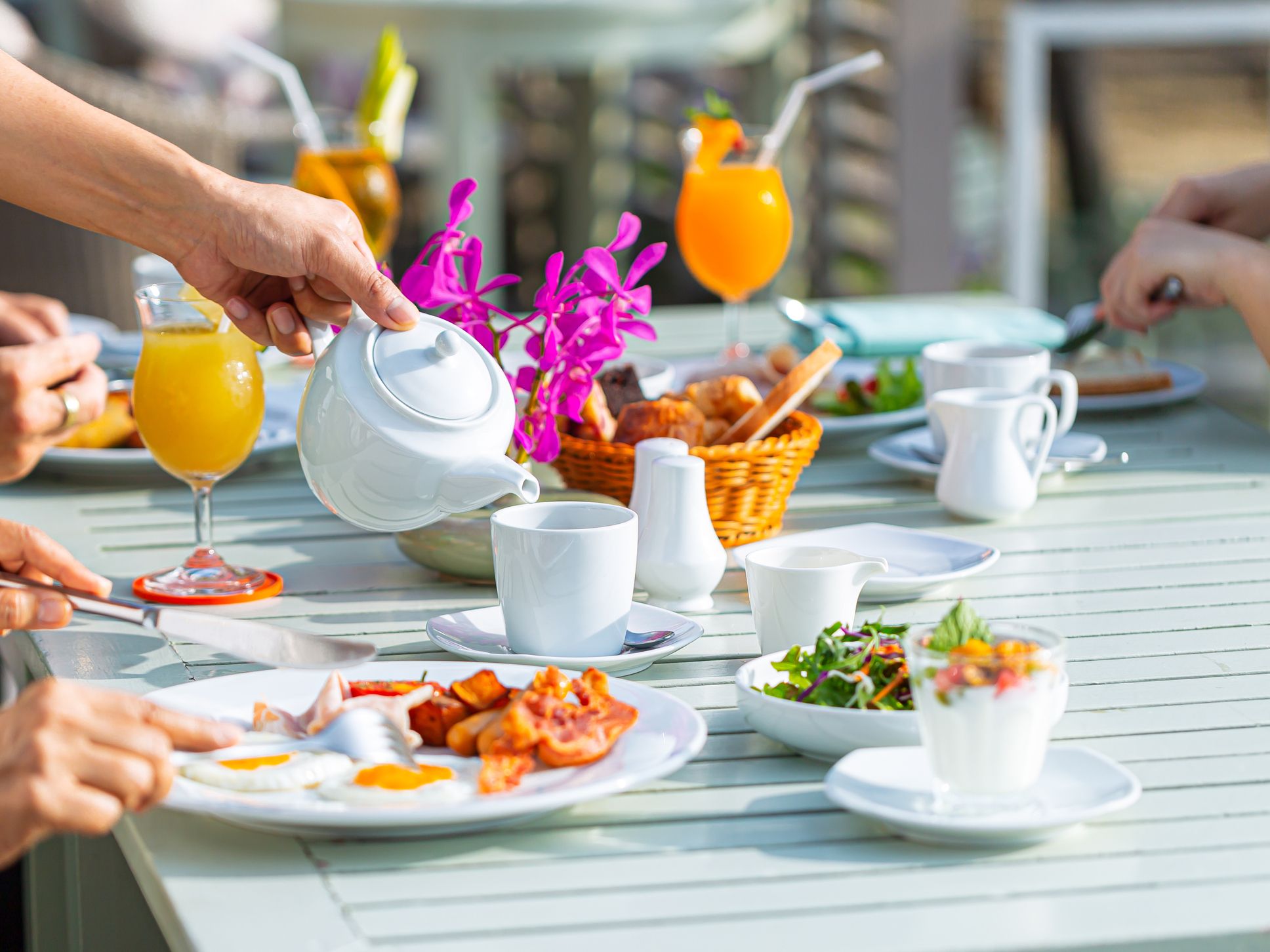 Puppy playing with champagne toy on hotel bed.