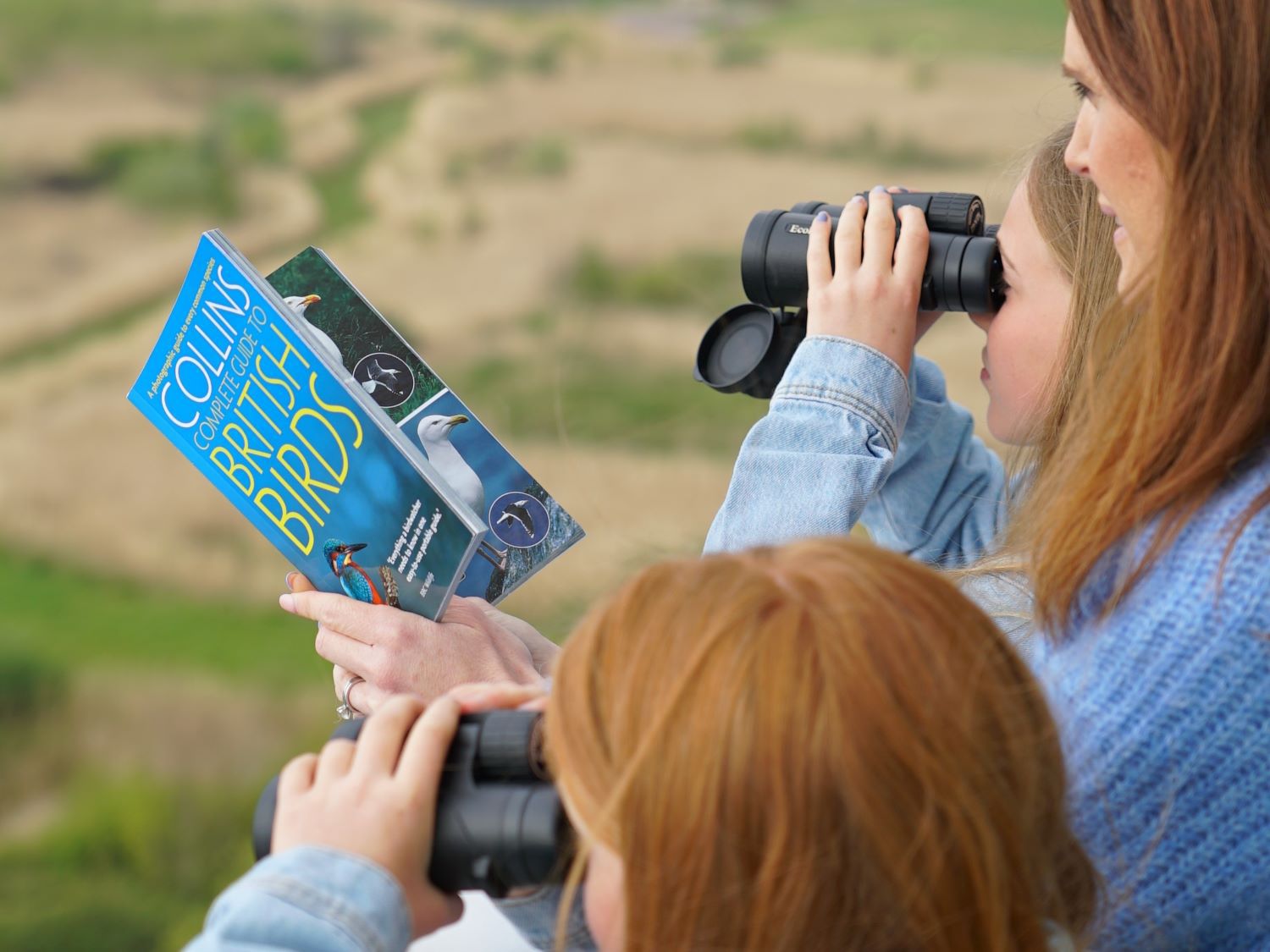 Family of three sight-seeing with binoculars 