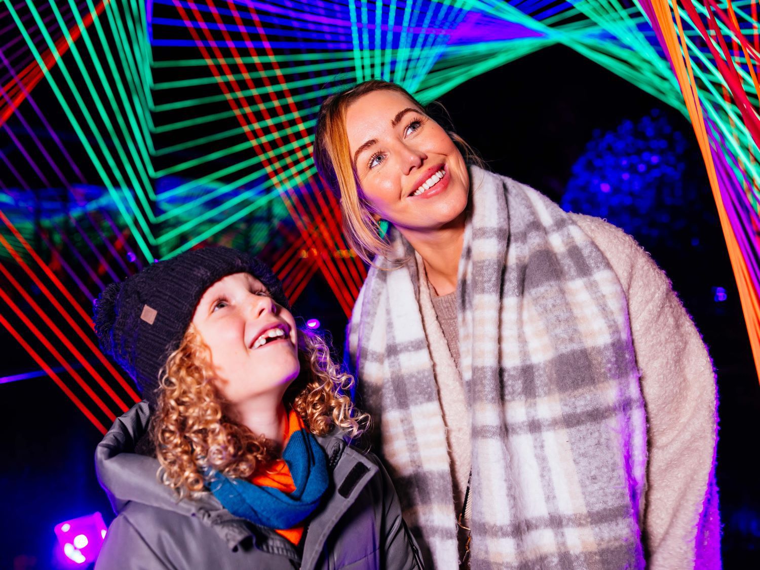 Two girls celebrating Christmas surrounded by Christmas lights