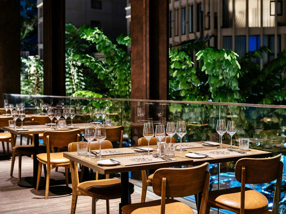 Outdoor dining area with elegant table settings and lush garden views.