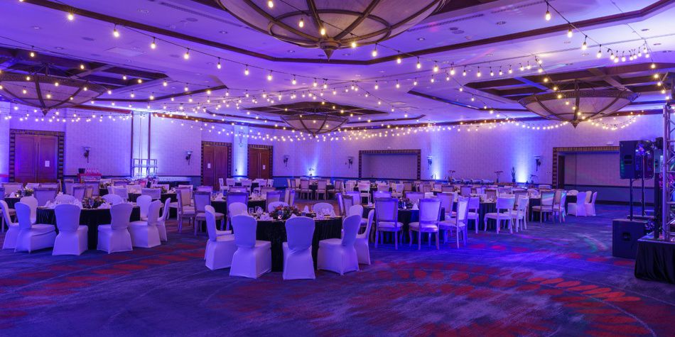 Ballroom set for event with round tables and string lights