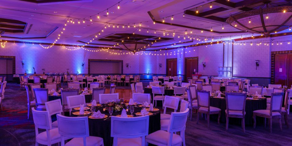 Event ballroom with banquet tables and hanging lights