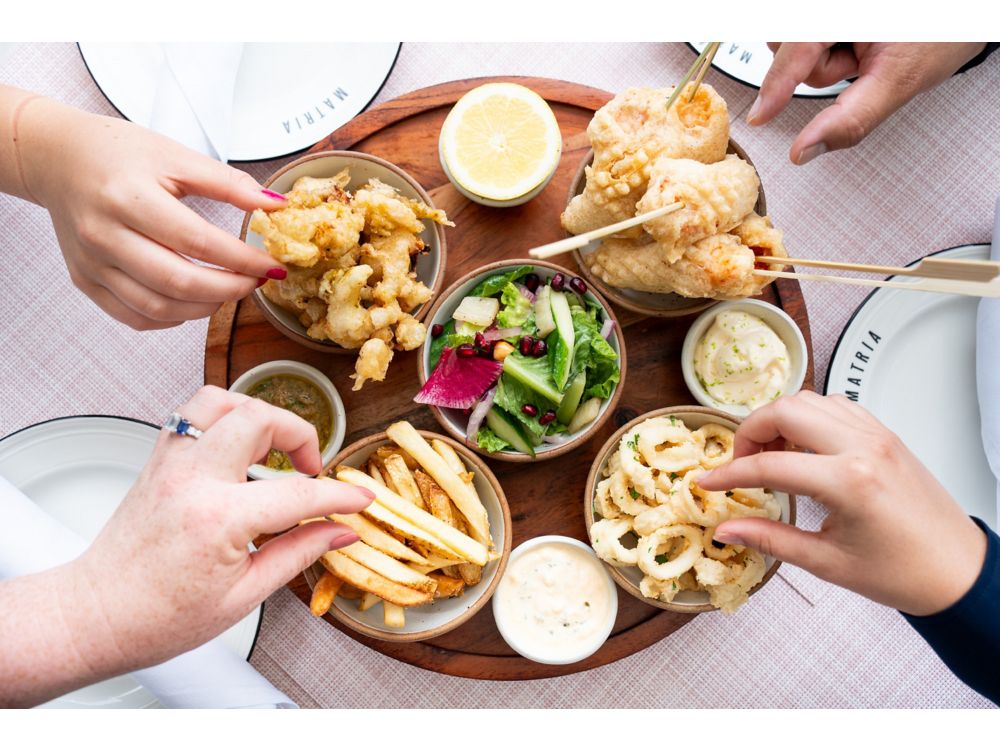 Guests enjoying small plates of sharable bites at Matria 