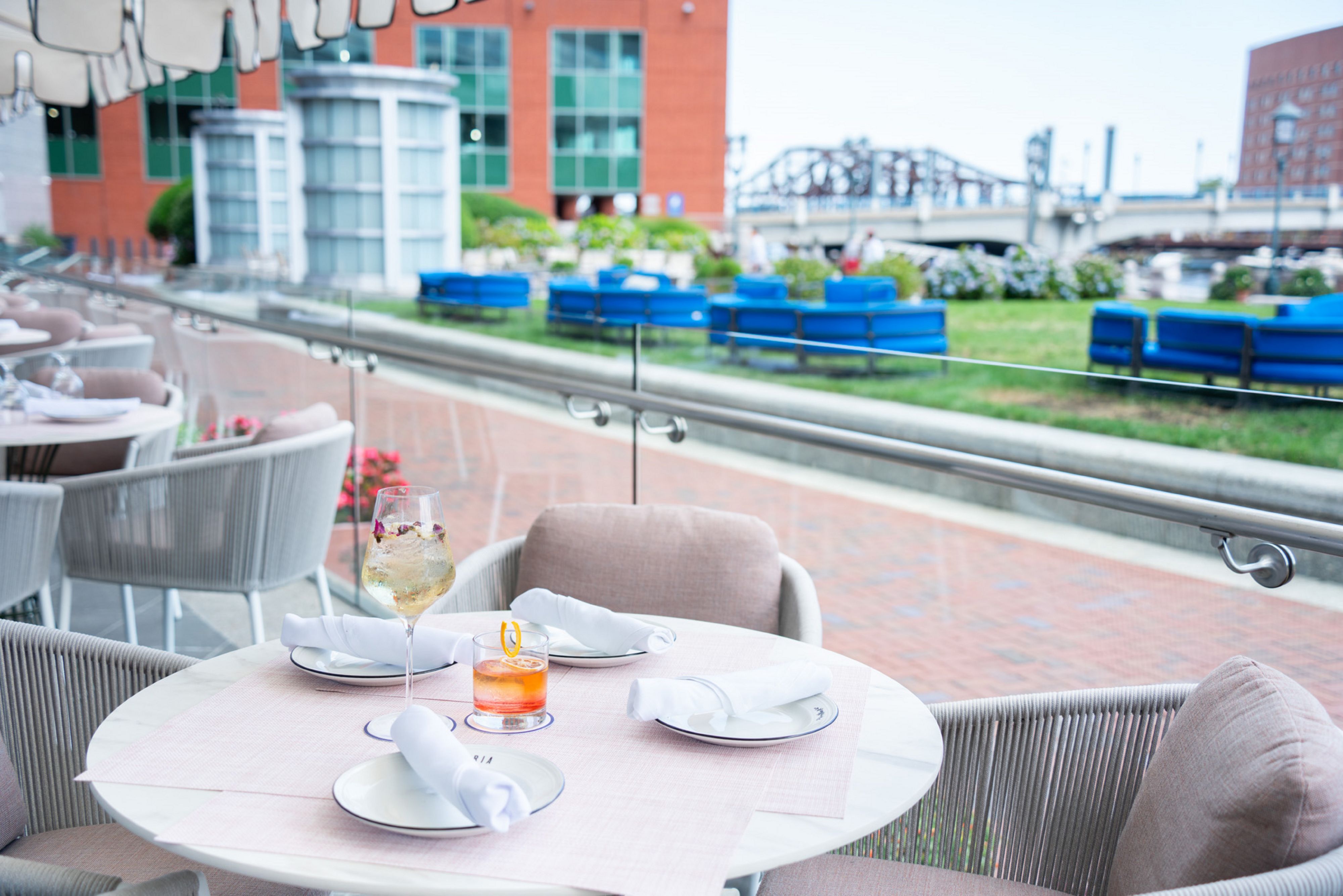 Crafted cocktails on a Matria outdoor patio table overlooking the Boston Harbor 