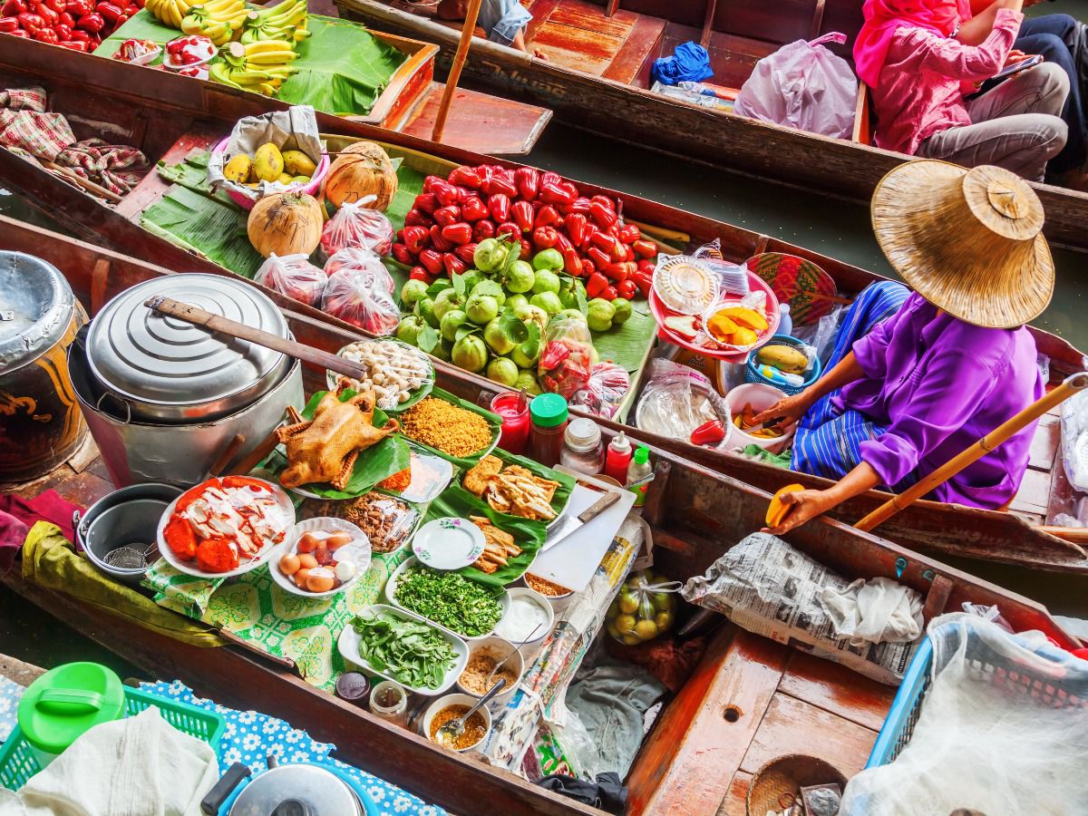 Colorful floating market with vendors selling fresh produce from boats.