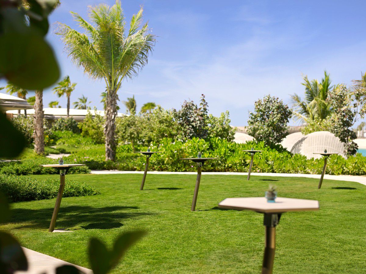 Lush tropical lawn with outdoor catering tables.