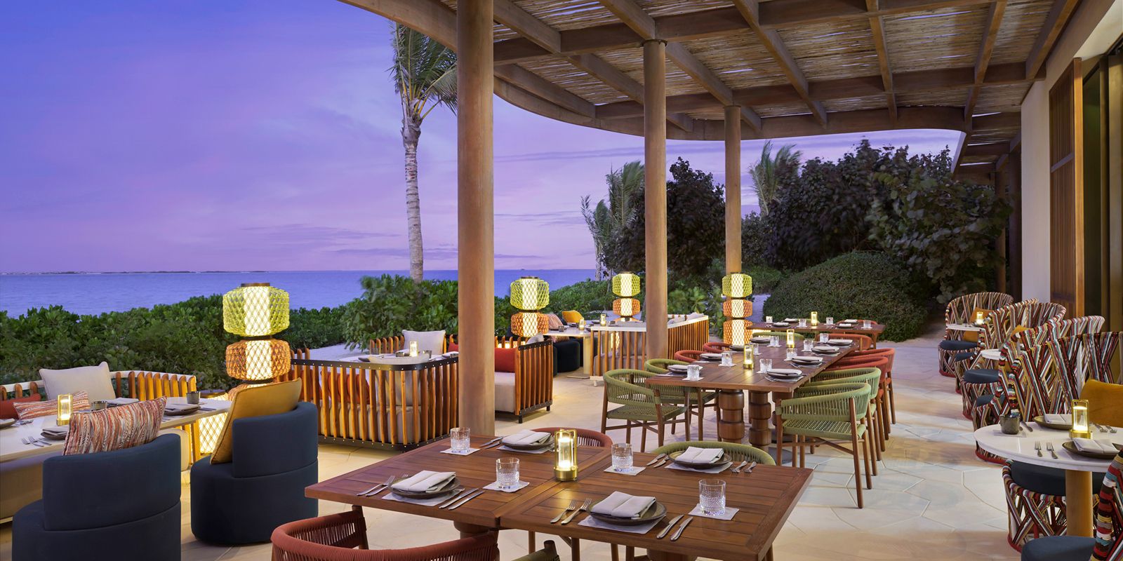 Dine under soft evening lights with breathtaking seaside serenity.