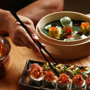 Sushi and dim sum served with chopsticks at table