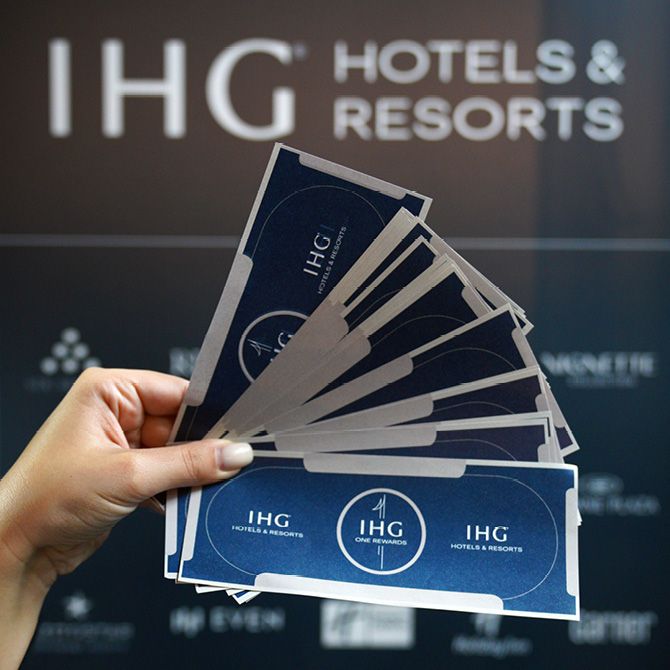 Meet us & Win: A hand holding gift vouchers of IHG Hotels & Resorts