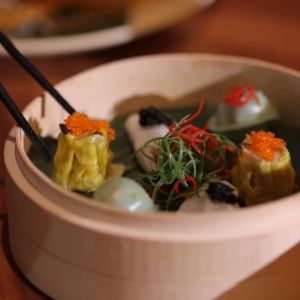 Dim sum dumplings and garnishes served in a bowl