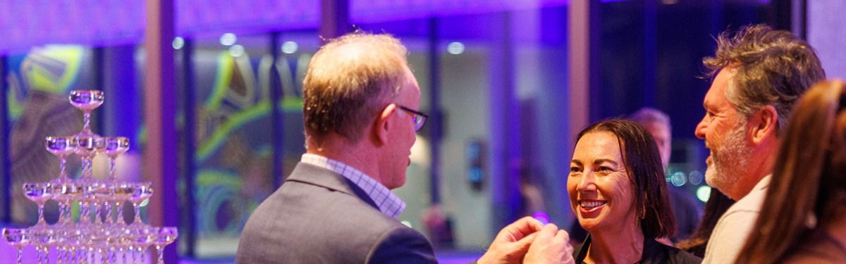 Guests socializing at an evening event with drinks.