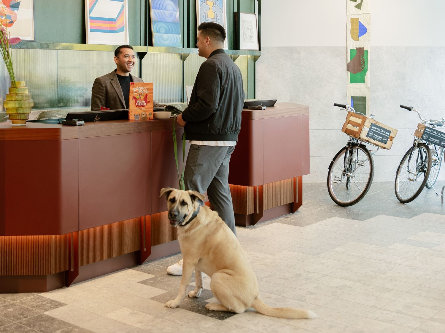 Man and dog in hotel lobby talking to reception