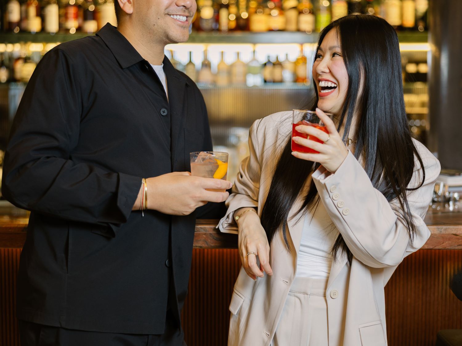 A couple at a bar laughing