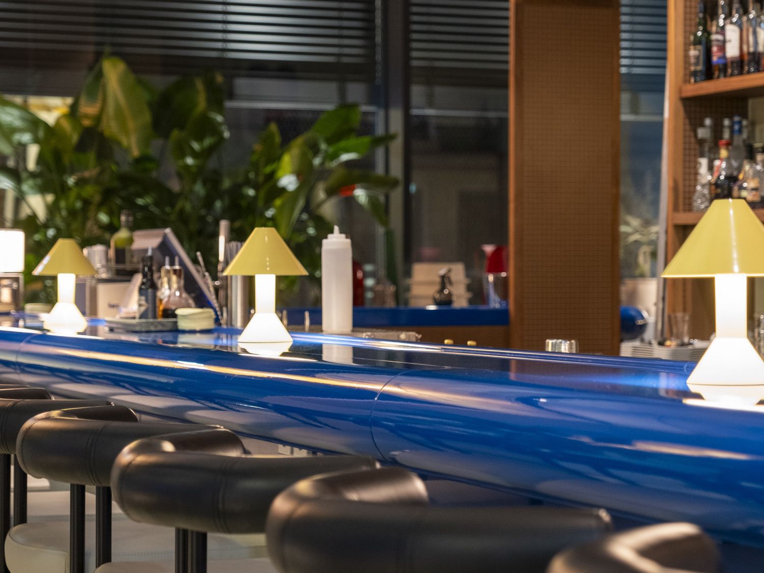lazuli bar area with blue countertop, high seats and decorative lamps
