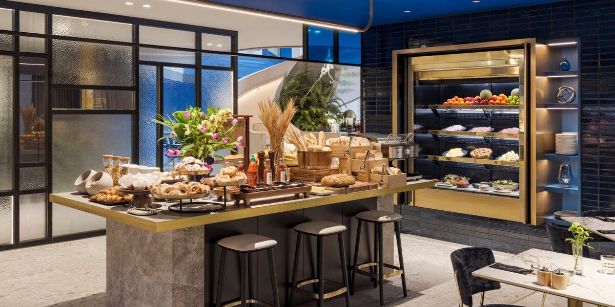 Modern dining buffet with pastries and seating.