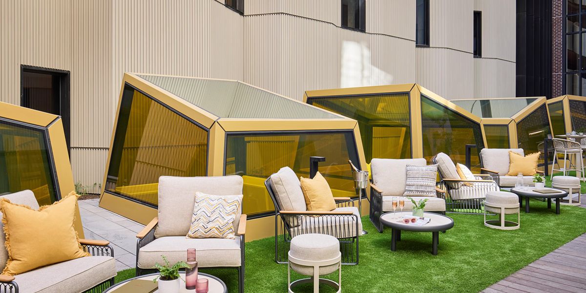Outdoor lounge seating with green lawn and pods.