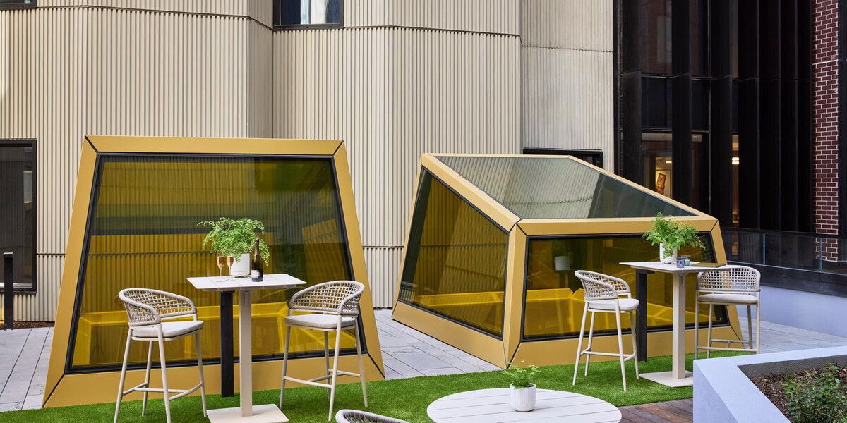 Outdoor dining pods with tables and chairs.