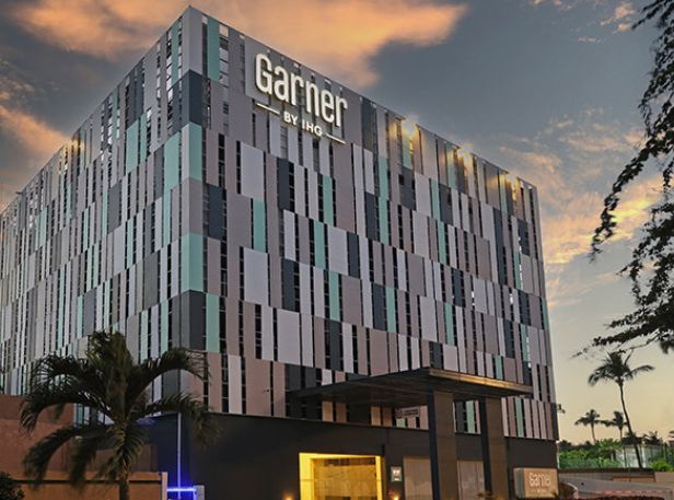 Modern hotel exterior with geometric facade and sunset lighting