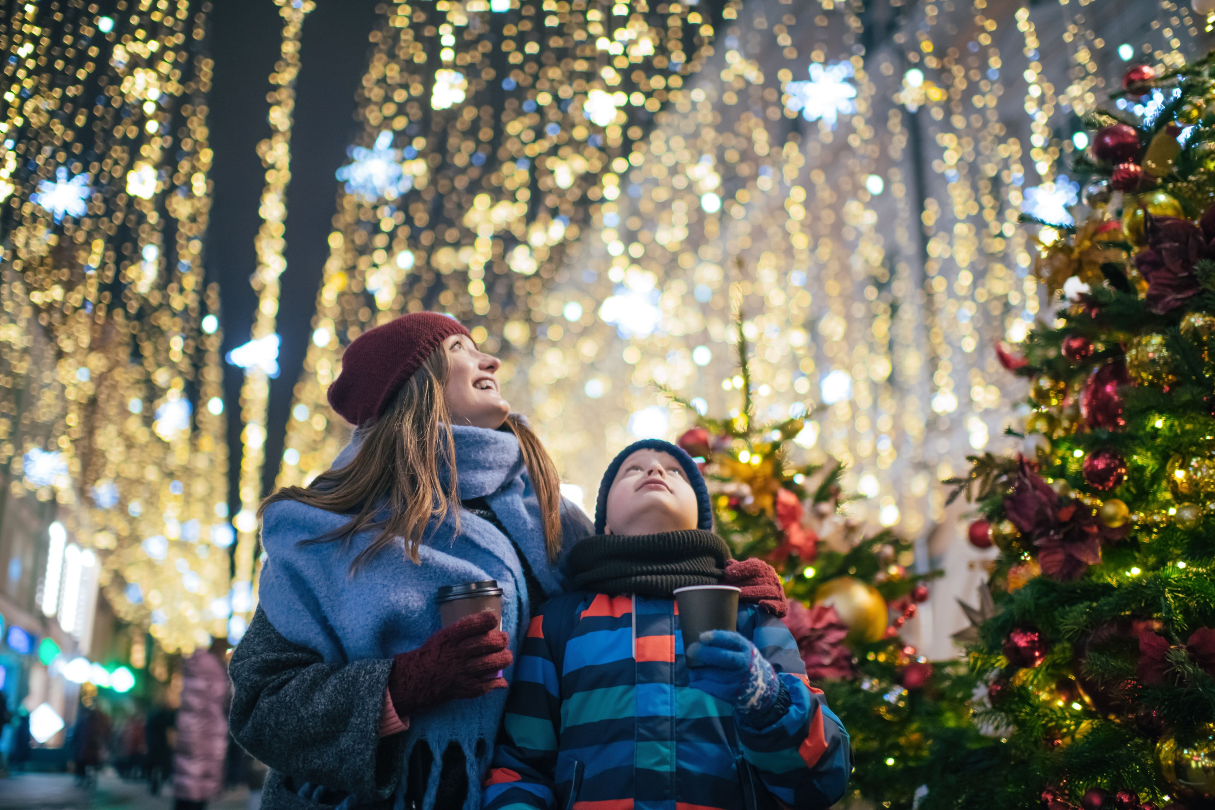 Little boy with his mother buying tera and sweets at a Christmas market