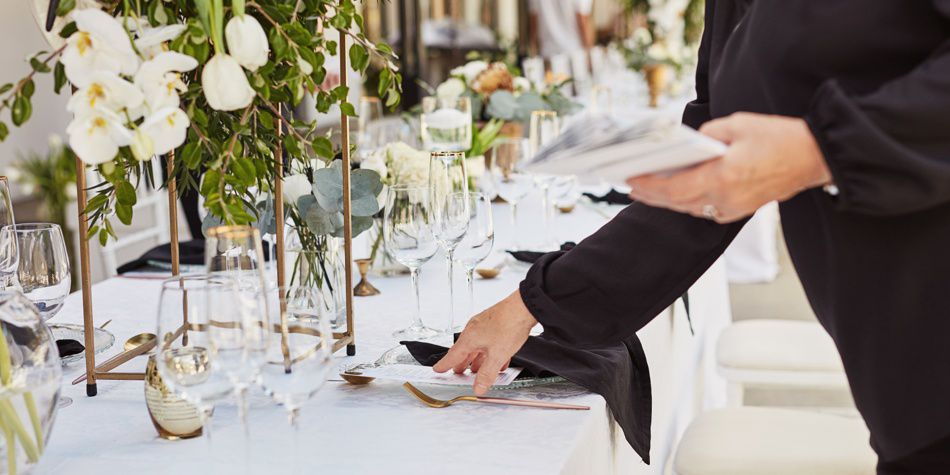 Event table setup with greenery and glassware arrangements