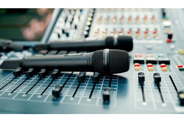 Microphones are on the sound console on the street before a live performance. 