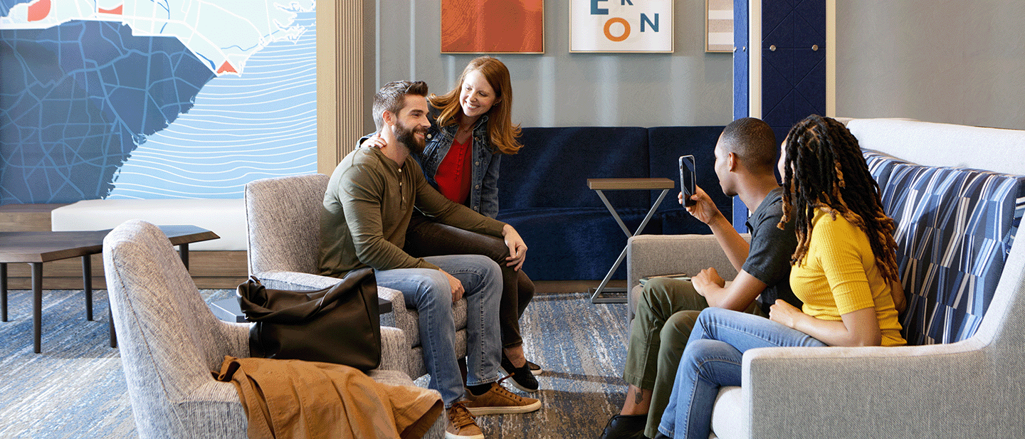 lobby with two couples, one taking a photo of the other while