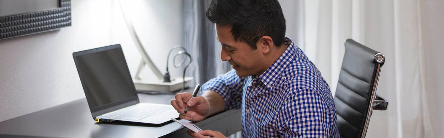 Man in hotel room working at desk