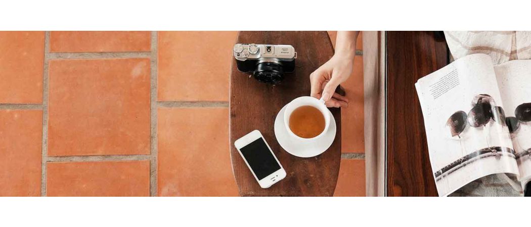 Hand holding a teacup on a table