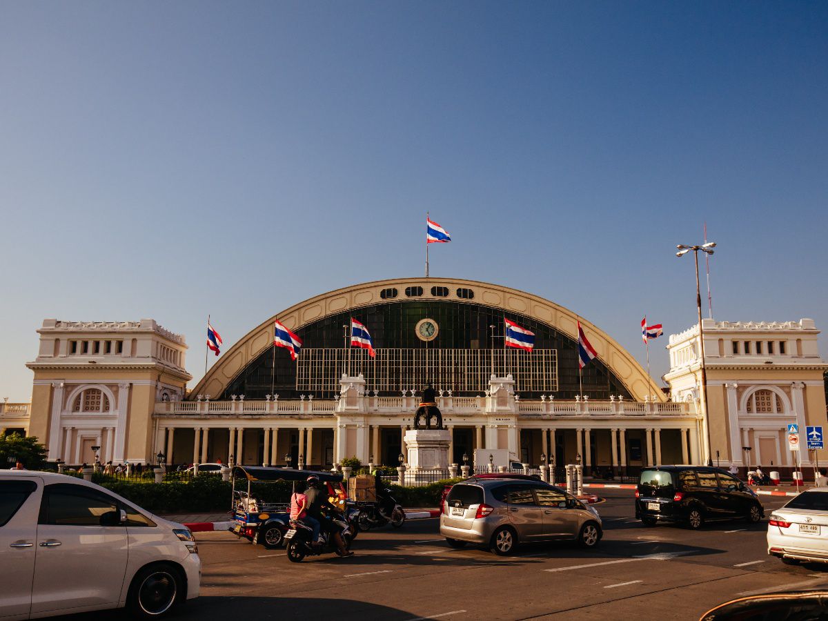 Historic railway station with classic architecture and national flags.