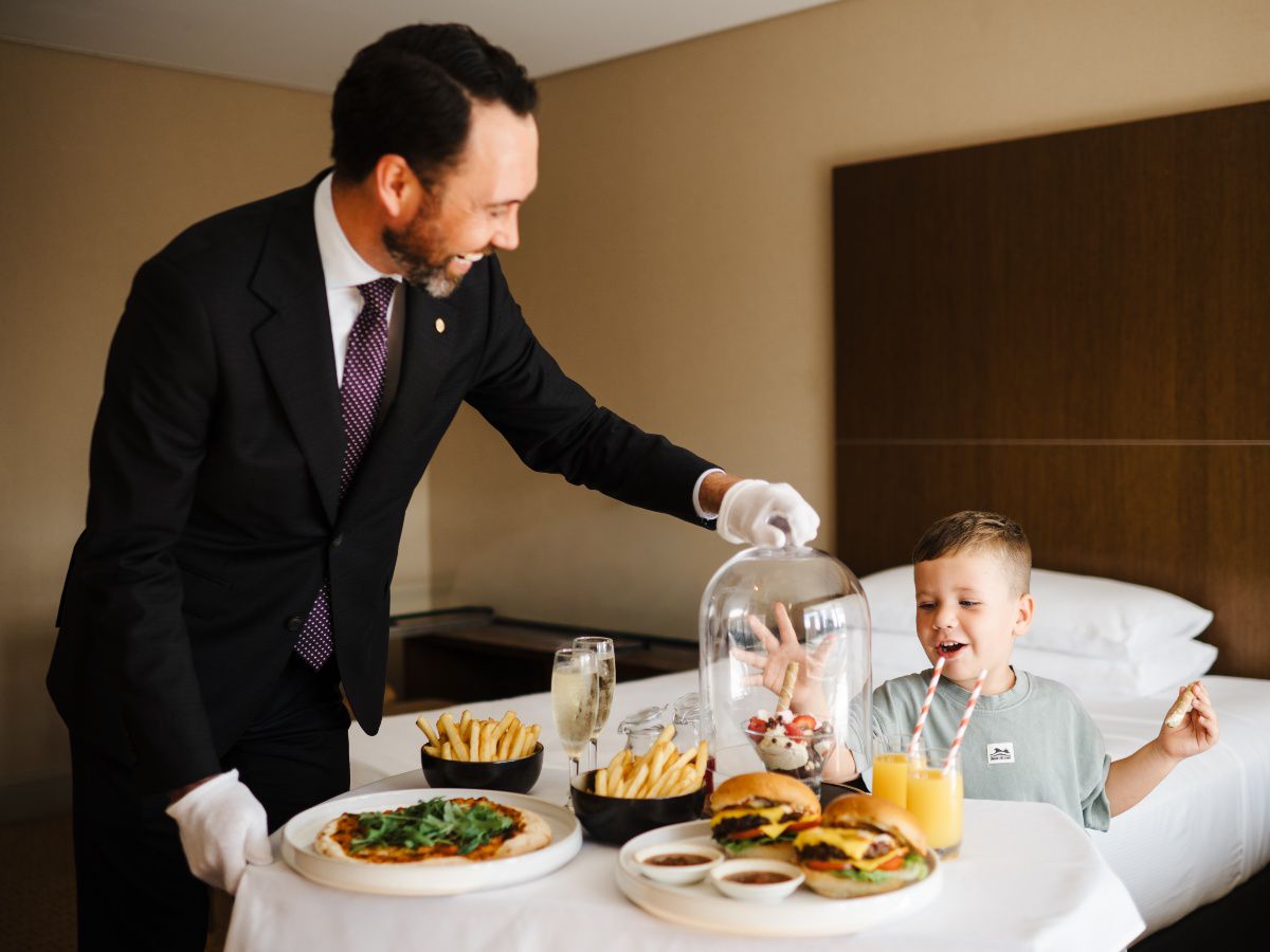 Family enjoying in-room dining with attentive hotel service