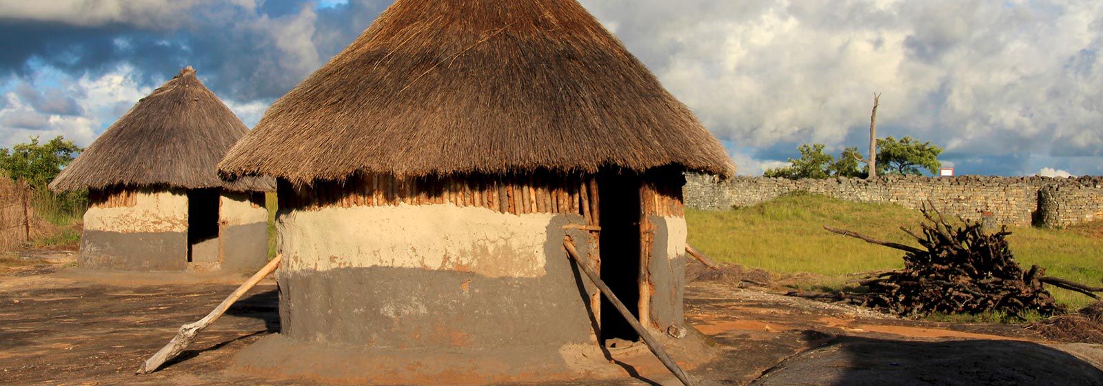 Two stick and mud huts with thatch roofs 