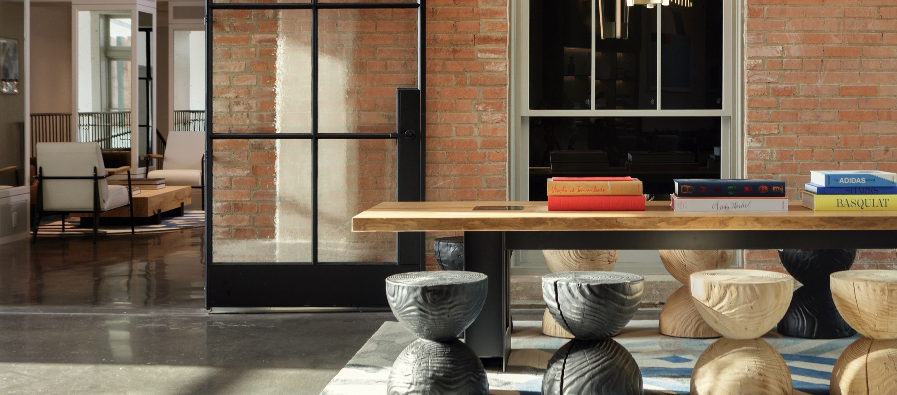 lobby living room with stool seating against an exposed brick wall