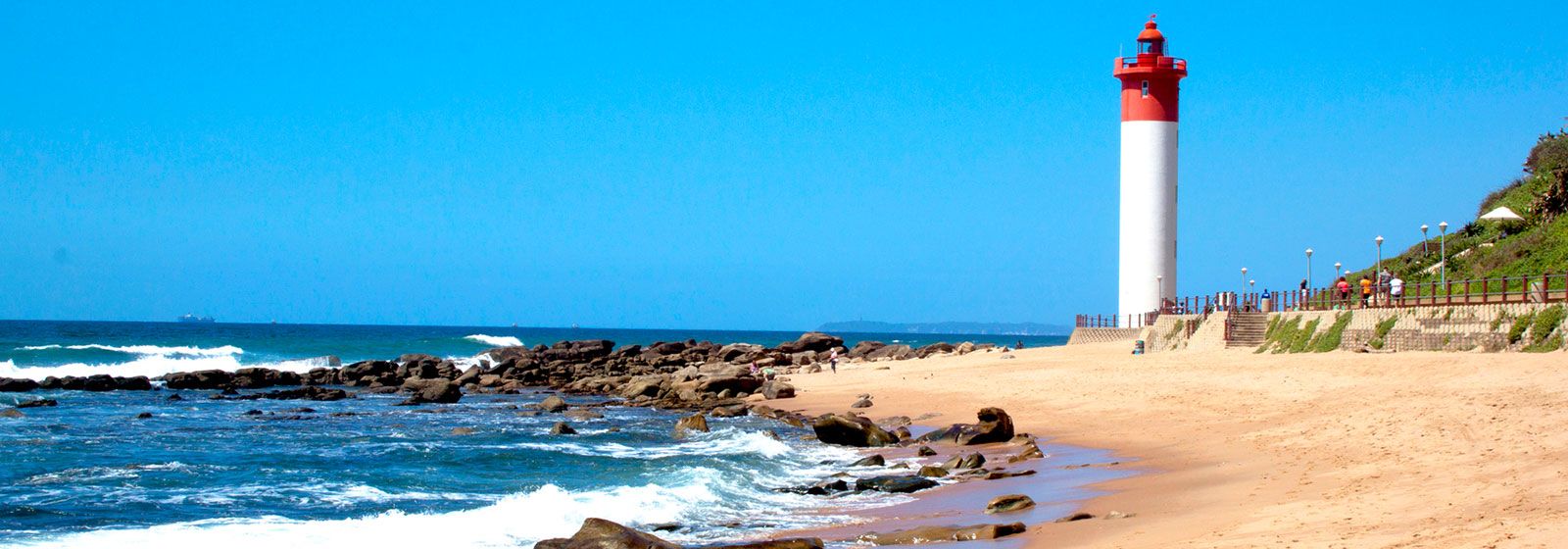 Tall red and white lighthouse on the coast in Durban