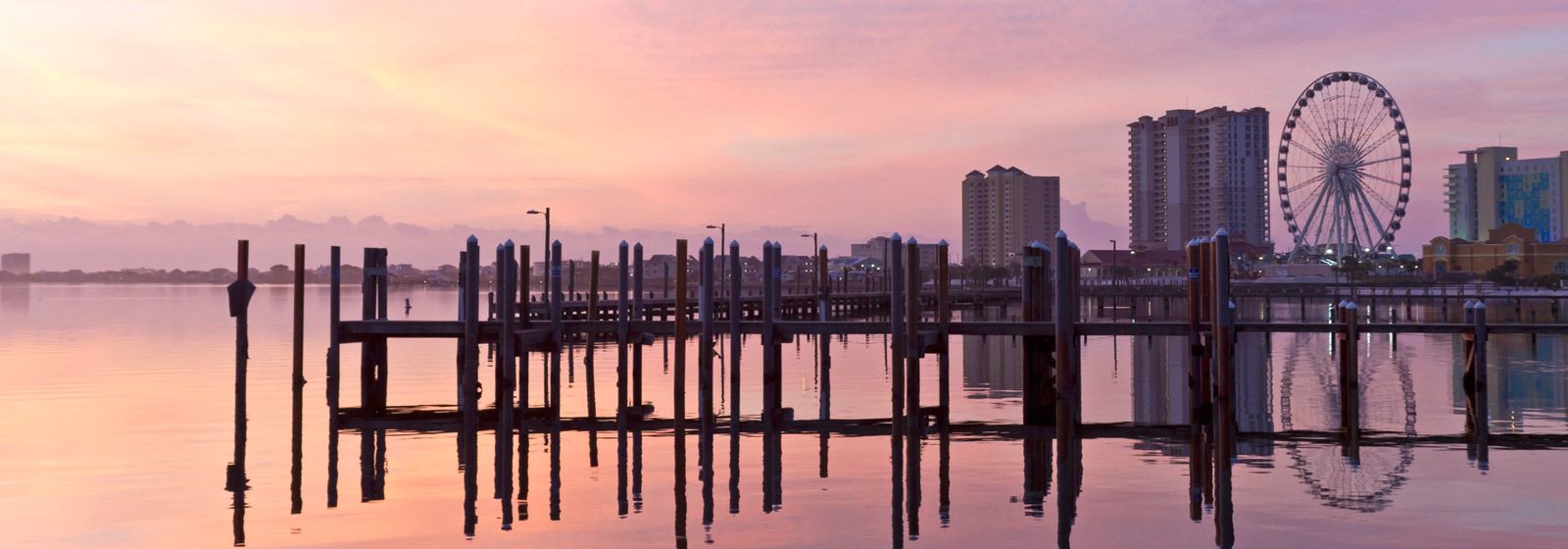 Vista de docas de madeira em frente a Pensacola Beach na hora do pôr do sol