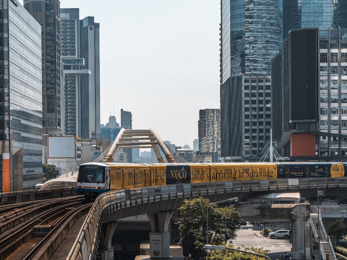Modern city skyline with an elevated train passing through urban buildings.