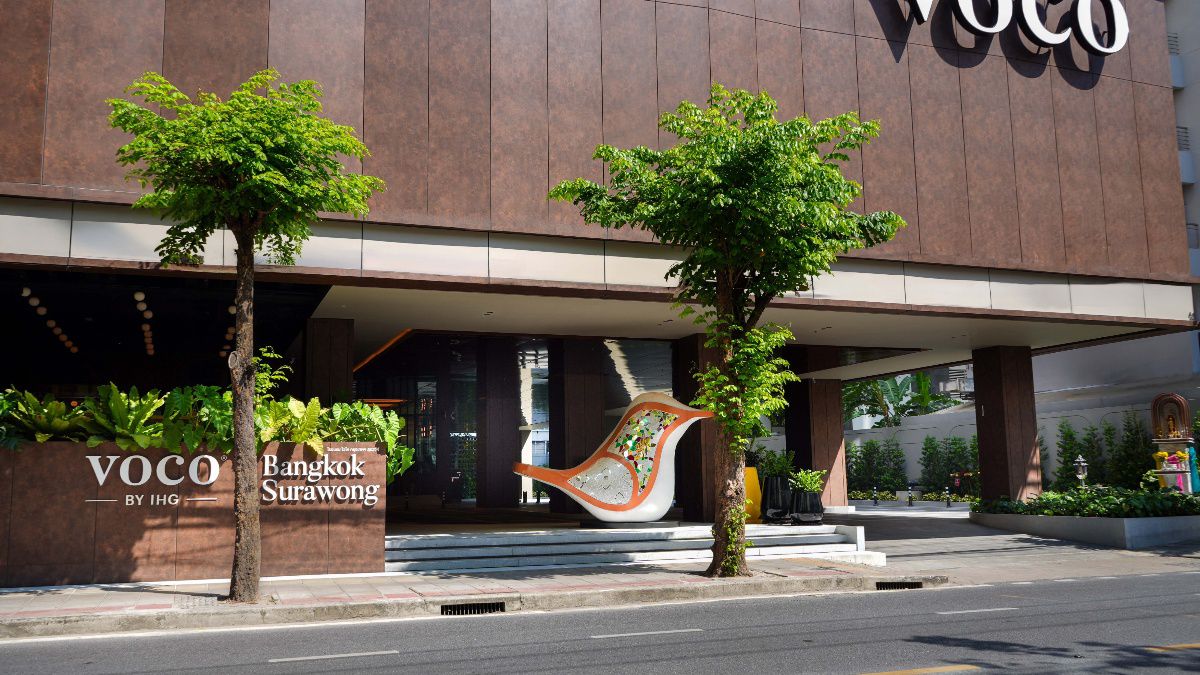 Hotel entrance with trees and modern exterior design.