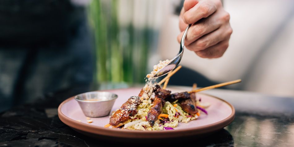 Ched at Azure plating a meat skewer plate