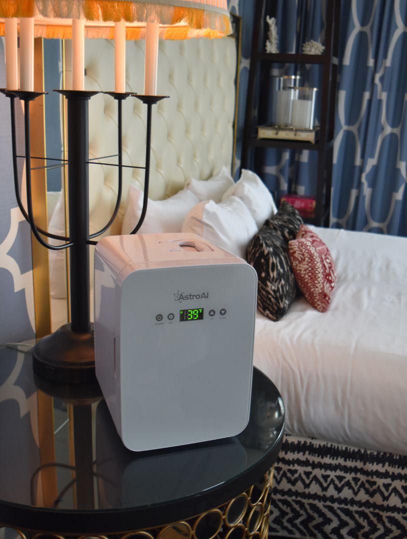 small fridge on a bed side table