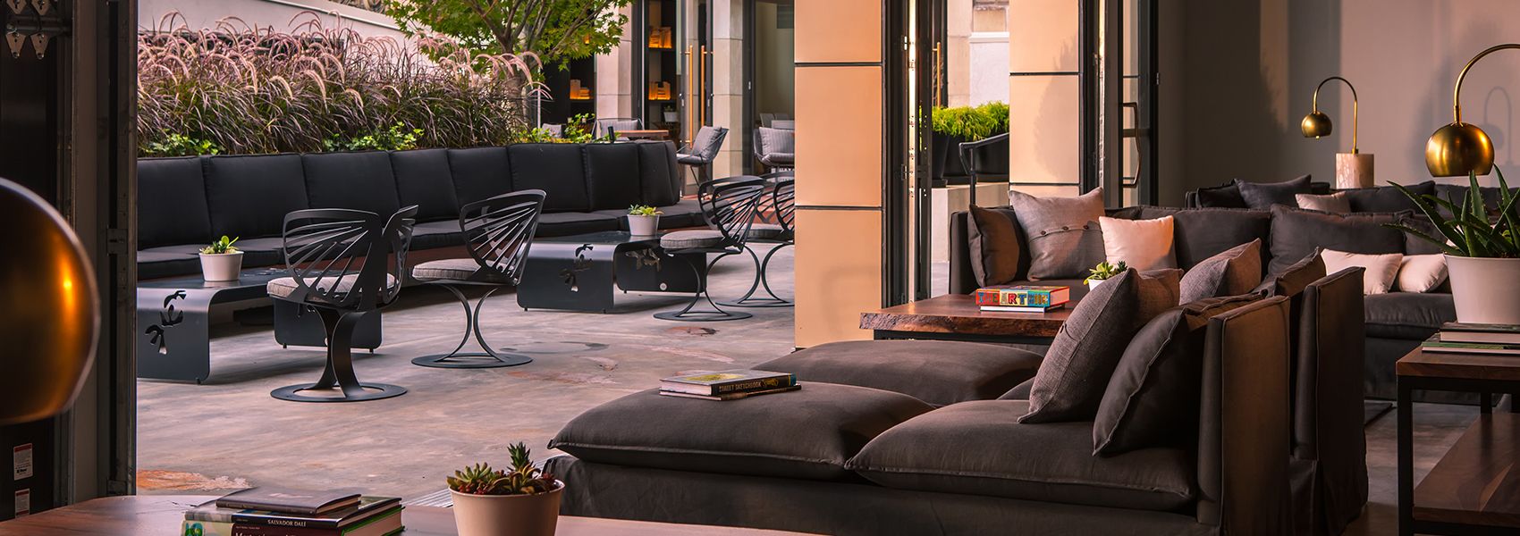 outdoor rooftop space with sophisticated decor, leafy greenery, and lounge seating