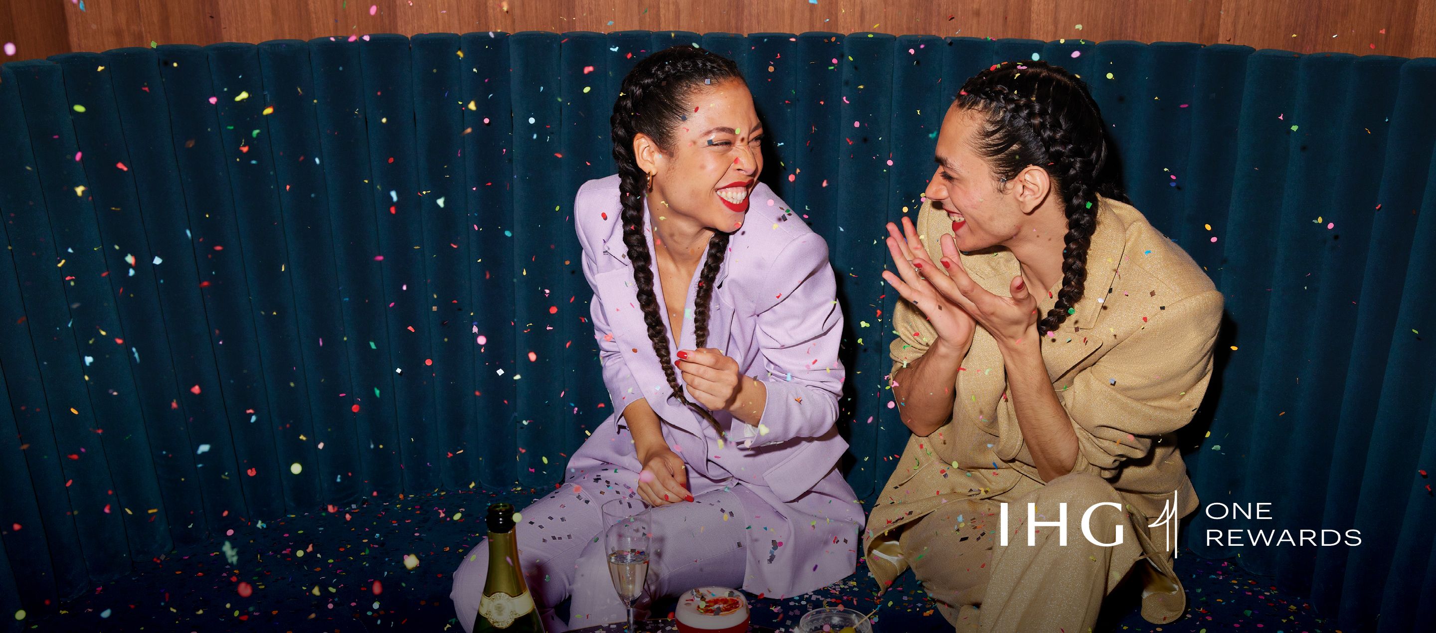 two girls sitting and laughing surrounded by confetti and festive vibe