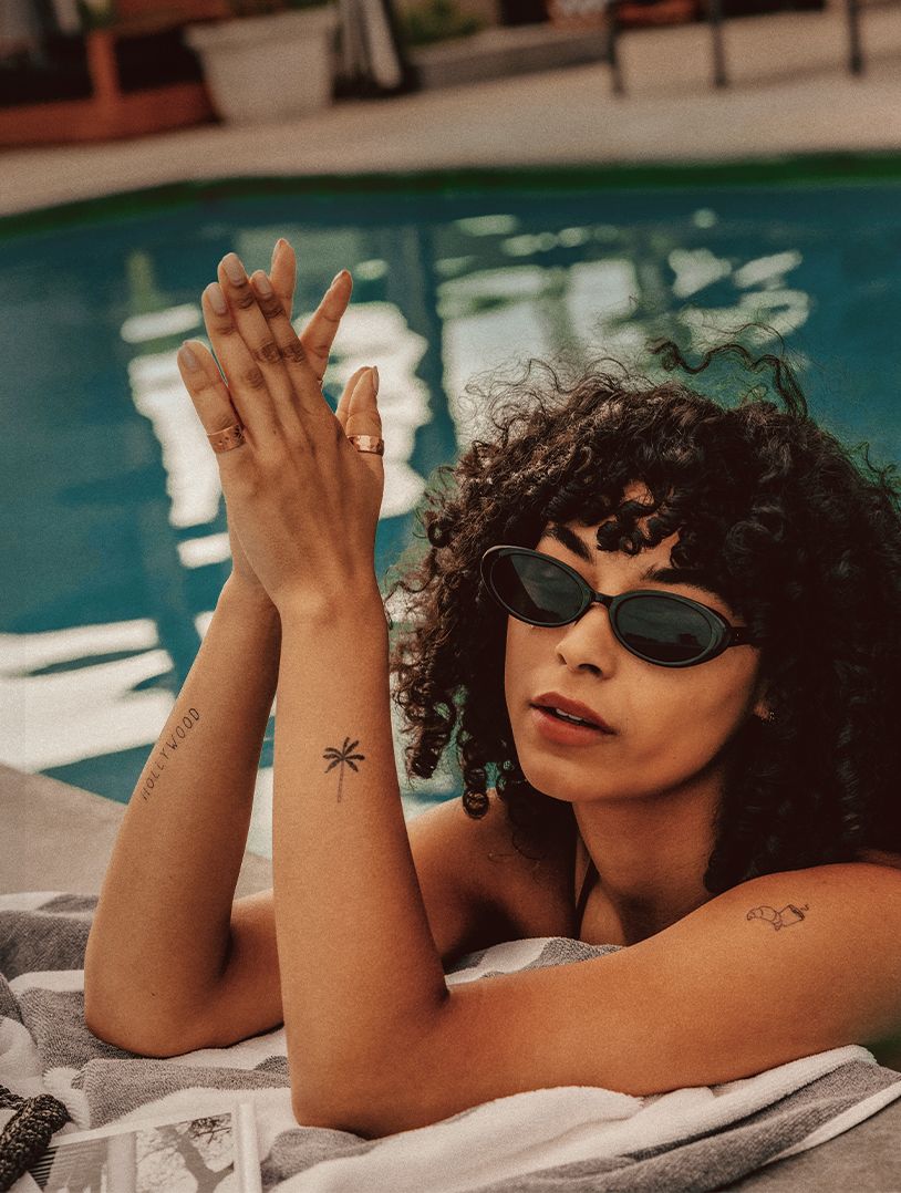 woman in pool showing tiny tattoos